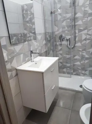 a bathroom with a white sink and a shower at Appartamento a San Lorenzo Netsuhe in Rome