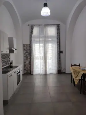 a kitchen with a large window with a table and a tableablish at Appartamento a San Lorenzo Netsuhe in Rome