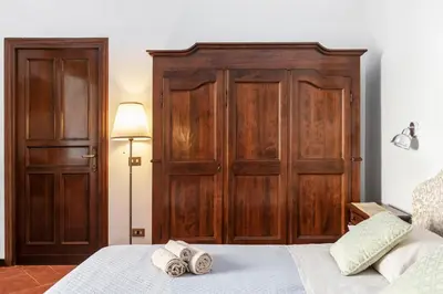 a bedroom with wooden doors and a bed with towels at Anima Beauty House in Rome