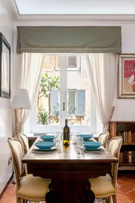a dining room table with chairs and a window at Anima Beauty House in Rome