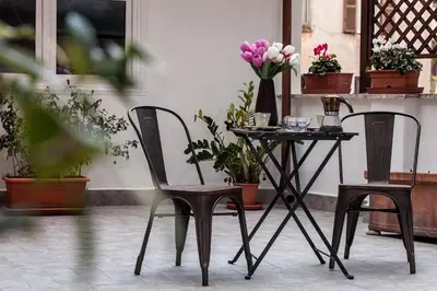 a table with two chairs and a table with flowers at Roma Capoccia in Vaticano in Rome