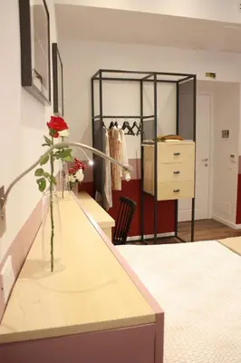 a room with a dresser and a vase with a rose in it at Roma Capoccia in Vaticano in Rome