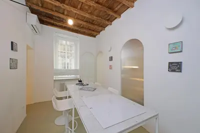 a kitchen with a table and a stainless steel refrigerator at 4BNB - Luxury Navona Apartment in Rome