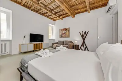 a white bedroom with a bed and a tv at 4BNB - Luxury Navona Apartment in Rome