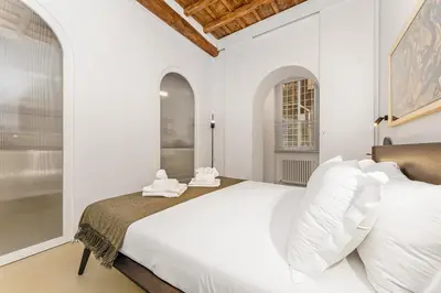 a white bedroom with a large bed with white pillows at 4BNB - Luxury Navona Apartment in Rome