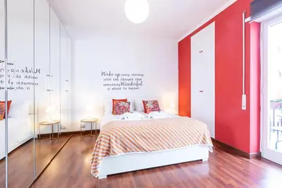 a bedroom with a bed and a red wall at Maisonette Trastevere Wonderful Apartment - Top Collection in Rome