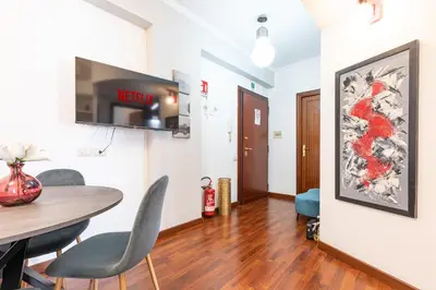 a dining room with a table and a tv on a wall at Maisonette Trastevere Wonderful Apartment - Top Collection in Rome