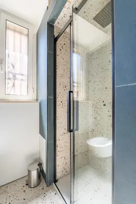 a glass shower in a bathroom with a sink at FAMM - Cozy flat in Trastevere in Rome