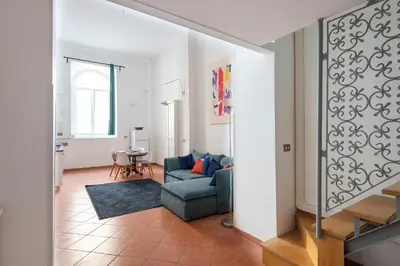 a living room with a blue couch and a table at Vittorio Elegant Two Bedroom Apartment in Rome