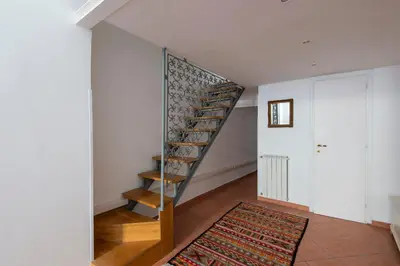 a spiral staircase in a room with a rug at Vittorio Elegant Two Bedroom Apartment in Rome
