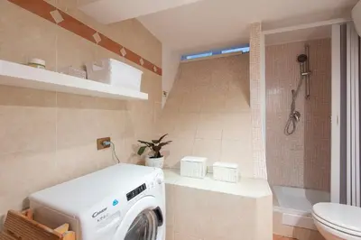 a bathroom with a washing machine and a toilet at Vittorio Elegant Two Bedroom Apartment in Rome