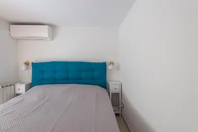 a bed with a blue headboard in a room at Vittorio Elegant Two Bedroom Apartment in Rome