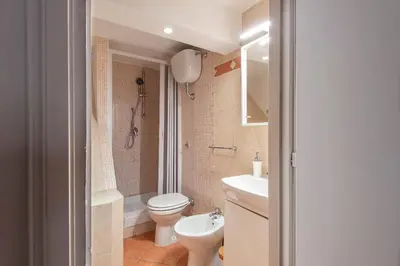 a bathroom with a toilet and a sink and a shower at Vittorio Elegant Two Bedroom Apartment in Rome