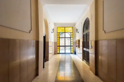 a hallway of a building with a door and a window at Vittorio Elegant Two Bedroom Apartment in Rome