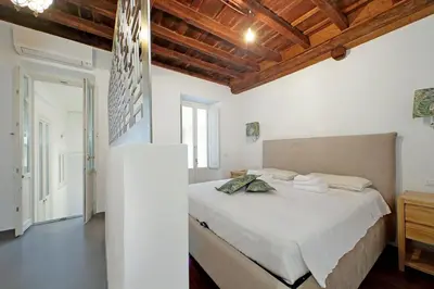 a bedroom with a bed in a room with wooden ceilings at Monti SPQR suite in Rome