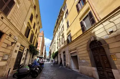 a narrow alley with buildings and motorcycles on a street at Monti SPQR suite in Rome