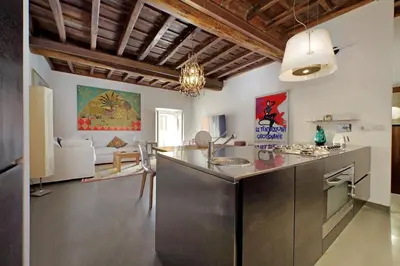 a kitchen with a stainless steel counter and a living room at Monti SPQR suite in Rome