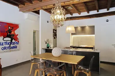 a dining room with a table and a chandelier at Monti SPQR suite in Rome