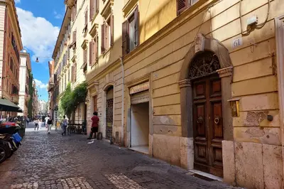 a cobblestone street in a city with a building at Monti SPQR suite in Rome