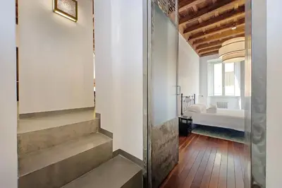 a hallway with stairs leading to a room with a bed at Monti SPQR suite in Rome
