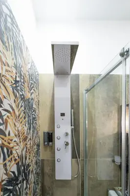 a bathroom with a shower with a glass door at Trastevere Luxury Rooms in Rome