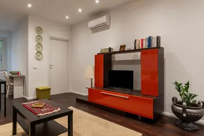 a living room with a tv in a red entertainment center at GuestHost - Sant'Agnese & Nomentana Cozy Apartment in Rome