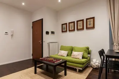 a living room with a green couch and a table at GuestHost - Sant'Agnese & Nomentana Cozy Apartment in Rome