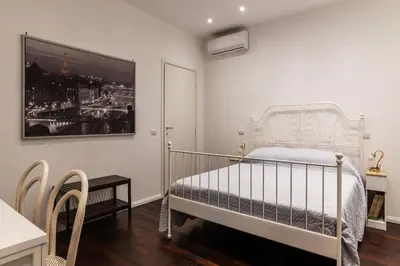 a bedroom with a white bed and a picture on the wall at GuestHost - Sant'Agnese & Nomentana Cozy Apartment in Rome