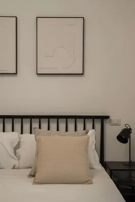 a bedroom with a bed with two pictures on the wall at Toscana 5 - FromHometoRome in Rome