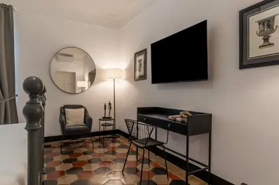 a living room with a television and a chair at Toscana 5 - FromHometoRome in Rome