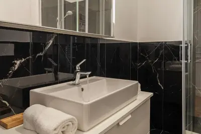 a bathroom with a white sink and a mirror at Toscana 5 - FromHometoRome in Rome