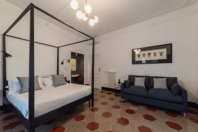 a bedroom with a four poster bed and a couch at Toscana 5 - FromHometoRome in Rome
