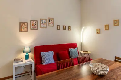 a living room with a red couch and a table at Cozy Apartment in Trastevere in Rome