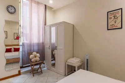 a bedroom with a bed and a cabinet and a clock at Cozy Apartment in Trastevere in Rome