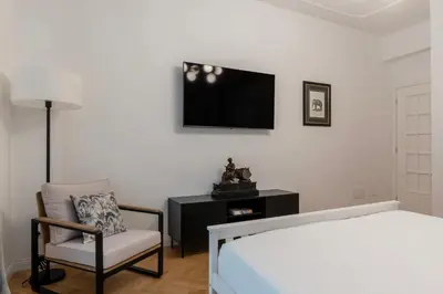 a bedroom with a bed and a chair and a tv at Toscana 2bis - FromHometoRome in Rome