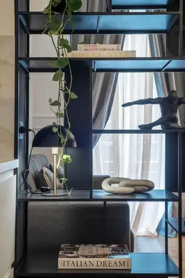 a black shelf with a plant and a book at Toscana 2bis - FromHometoRome in Rome