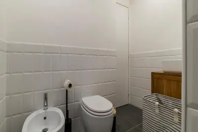 a white bathroom with a toilet and a sink at Toscana 2bis - FromHometoRome in Rome