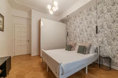 a bedroom with a bed with white sheets and a wall at Toscana 2bis - FromHometoRome in Rome