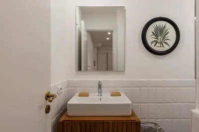 a bathroom with a white sink and a mirror at Toscana 2bis - FromHometoRome in Rome
