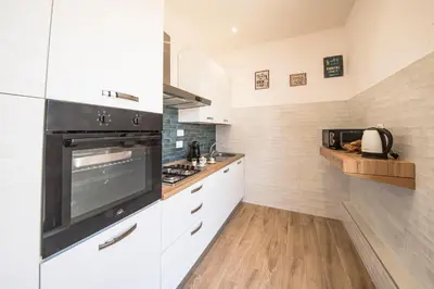 a kitchen with white cabinets and a stove top oven at Roof Terrace Sophie, Repubblica apartment Termini Station in Rome