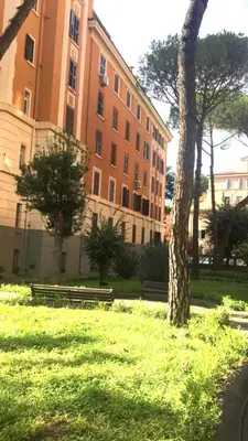 a building with a tree and benches in a park at Everlasting Zen Home in San Giovanni Rome in Rome