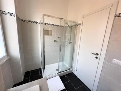 a shower with a glass door in a bathroom at St Pietro city center near subway in Rome