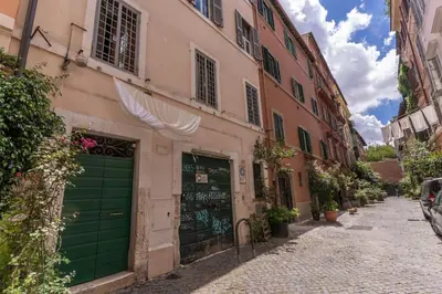 an alley with buildings and a green garage at Trastevere Vicolo del Leopardo suite in Rome