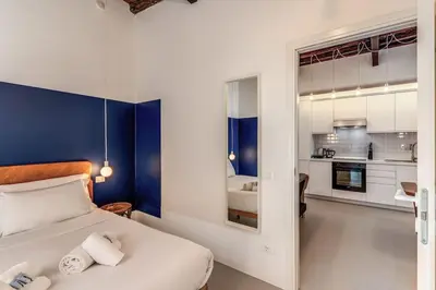 a bedroom with a large bed and a kitchen at Trastevere Vicolo del Leopardo suite in Rome