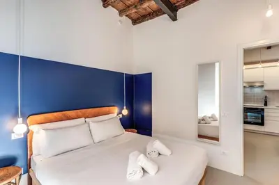 a bedroom with a large bed with a blue wall at Trastevere Vicolo del Leopardo suite in Rome