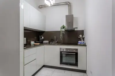 a kitchen with white cabinets and an oven at iFlat Cozy and Elegant apt near Spanish Steps in Rome