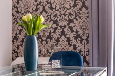 a blue vase with yellow flowers on a glass table at iFlat Cozy and Elegant apt near Spanish Steps in Rome