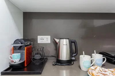 a kitchen counter with a coffee maker and coffee cups at iFlat Cozy and Elegant apt near Spanish Steps in Rome
