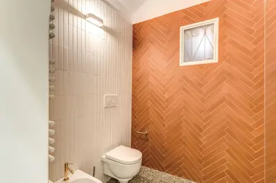 a bathroom with a toilet and a picture on the wall at 3 bedroom apartment Via Genova Monti area in Rome
