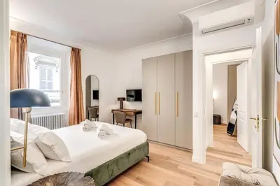 a white bedroom with a bed and a desk at 3 bedroom apartment Via Genova Monti area in Rome
